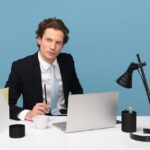 A man in a suit sitting at a desk with a laptop, focusing on risk management CRM